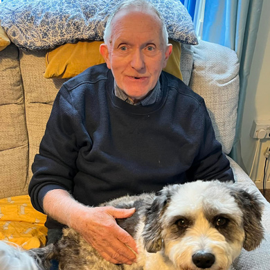 elderly man sitting on couch with dog joyful companionship ten years of memories