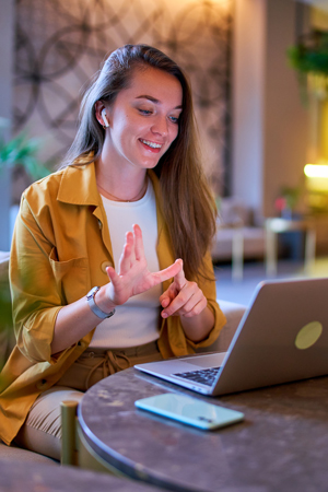 smiling woman gesturing while using laptop 9 digital communication skills 9 online meeting environment