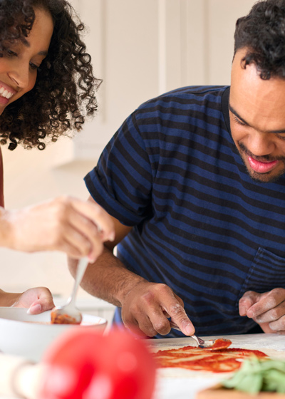 couple preparing pizza together enjoying cooking time