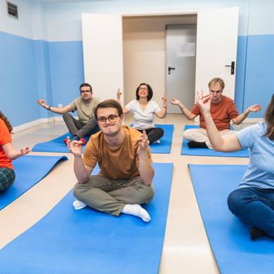 group of people meditating in a serene environment on yoga mats practicing mindfulness and relaxation techniques in a calming space with blue walls and yoga mats