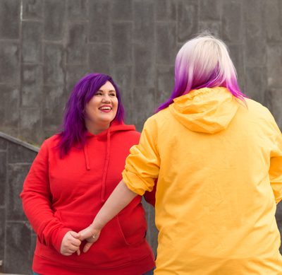 two friends wearing colorful hoodies enjoying time together with vibrant hairstyles representing a fun 12-year friendship