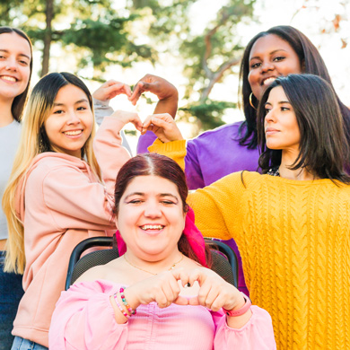 group of five women making heart shapes with their hands celebrating friendship diversity and connection featuring people with different hairstyles and outfits in a bright outdoor setting 16 reasons to cherish love