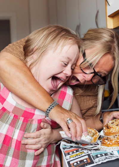 two joyful women enjoying pastries together in a kitchen laughing and having fun with each other delightful moments with three pastries