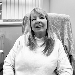 smiling woman wearing a white hoodie sitting comfortably in an office chair showcasing a relaxed atmosphere and five reasons to smile